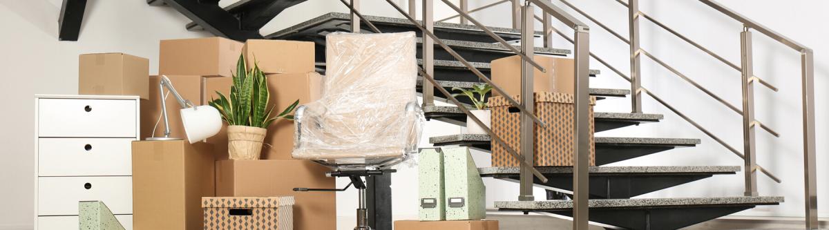 Boxes and office furniture ready to be loaded into a moving van